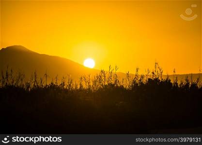 Scenic sunset or sunrise sun rising over mountain hill. Sunrise over mountain hill