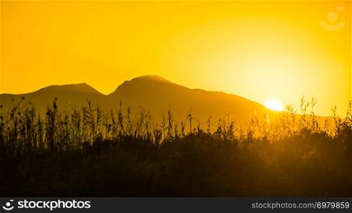 Scenic sunset or sunrise sun rising over mountain hill. Sunrise over mountain hill