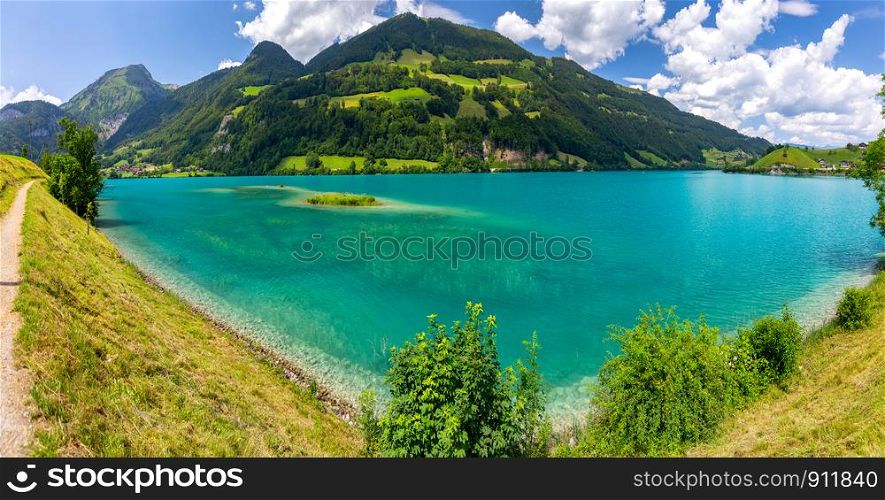 Scenic view of a blue mountain lake on a sunny day. Lungern Switzerland.. Lungern. Picturesque blue mountain lake in the Alps.