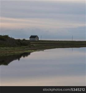Scenic view of calm river with house in background, Cheticamp, Cabot Trail, Cape Breton Island, Nova Scotia, Canada