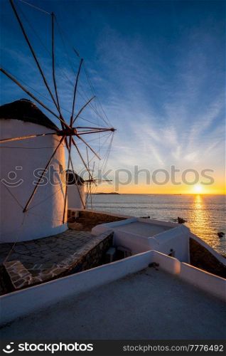 Scenic view of famous Mykonos Chora town windmills. Traditional greek windmills on Mykonos island illuminated in the evening, Cyclades, Greece. Walking with steadycam.. Traditional greek windmills on Mykonos island at sunrise, Cyclades, Greece