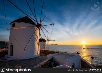 Scenic view of famous Mykonos town windmills. Traditional greek windmills on Mykonos island on sunset with dramatic sky, Cyclades, Greece. Walking with steadycam.. Traditional greek windmills on Mykonos island at sunrise, Cyclades, Greece