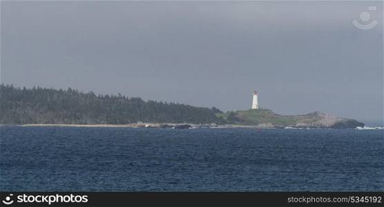 Scenic view of lighthouse at coast, Louisbourg Harbour, Louisbourg, Cape Breton Island, Nova Scotia, Canada