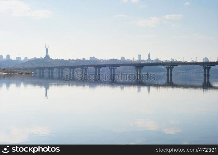 Scenic view of Mother Motherland monument above Dnipro river with Paton bridge and Kiev city skyline, Ukraine