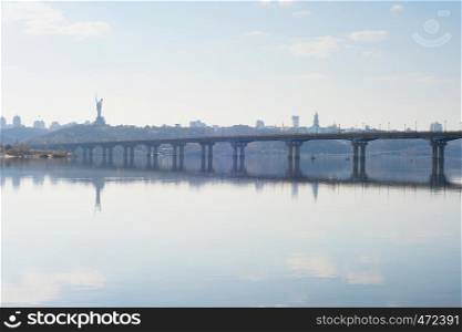 Scenic view of Mother Motherland monument above Dnipro river with Paton bridge and Kiev city skyline, Ukraine