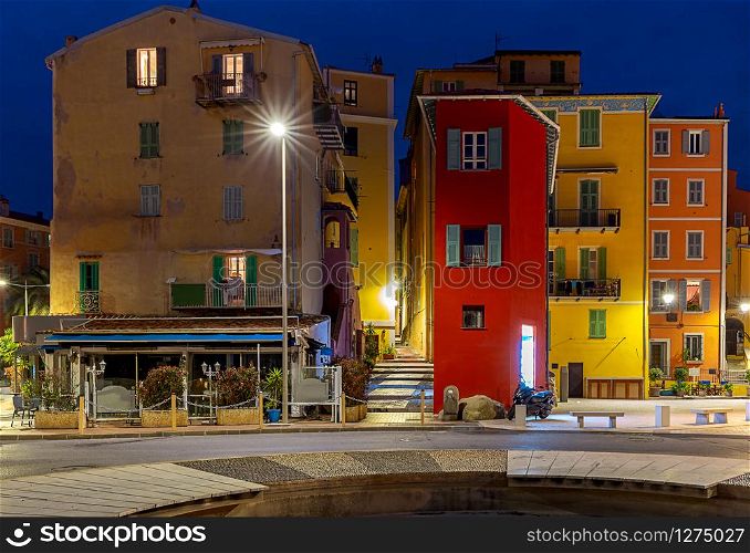 Scenic view of multi-colored medieval houses in the historical part of the city at night. Menton. France.. Menton. Antique multi-colored facades of medieval houses.
