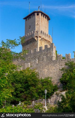 Scenic view of old medieval towers over the valley in the early morning. San Marino. Italy.. San Marino. Old stone towers on top of the mountain.