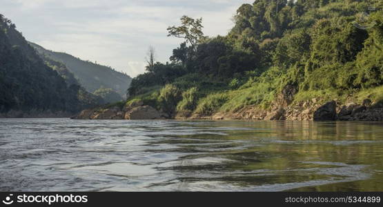 Scenic view of river shoreline with mountain range in background, River Mekong, Sainyabuli Province, Laos