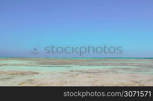 Scenic view of sea with clear shallow water and cloudless blue sky. Vacation at the seaside