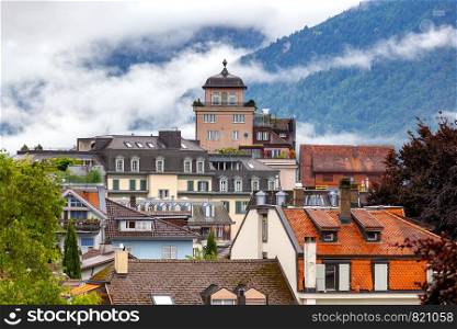 Scenic view of the city rooftops of the mountain on a cloudy day. Interlaken. Switzerland.. Interlaken. Aerial view of the city rooftops and mountains.