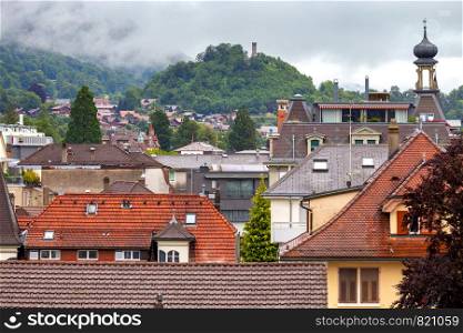 Scenic view of the city rooftops of the mountain on a cloudy day. Interlaken. Switzerland.. Interlaken. Aerial view of the city rooftops and mountains.