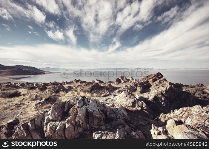 Scenic view of the Great Salt Lake landscape on a sunny day with white clouds on a blue sky.