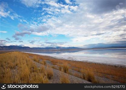 Scenic view of the Great Salt Lake landscape on a sunny day with white clouds on a blue sky.