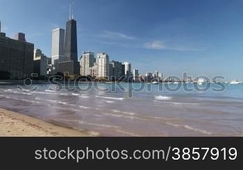 Scenic view of the Northern Chicago skyline from the beach by Navy Pier, with boats and Lake Michigan
