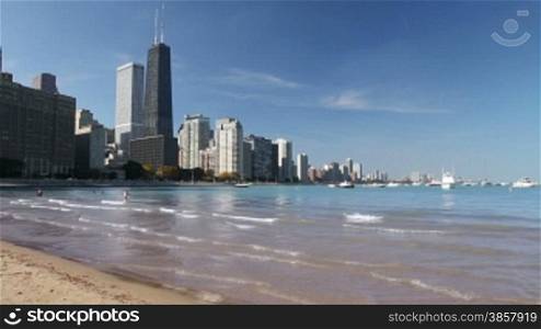 Scenic view of the Northern Chicago skyline from the beach by Navy Pier, with boats and Lake Michigan