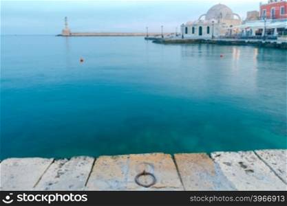 Scenic view of Venetian promenade with a lighthouse and the mosque Kucuk Hasan Pasha in the early morning, Crete, Greece.