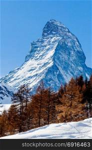 Scenic view on snowy Matterhorn peak in sunny day with blue sky. Switzerland