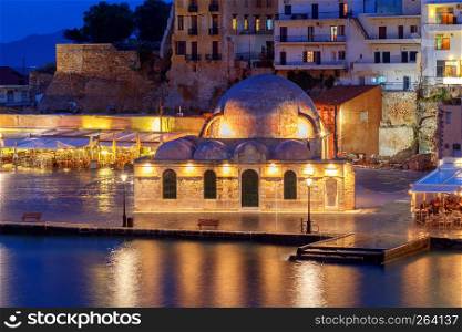 Scenic view Venetian embankment in Chania with the Mosque of Hassan Kuchuk Pasha at night. Crete, Greece.. Venice embankment in the old harbor of Chania.