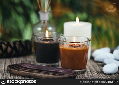 Scented brown candles. Pine cone and essential oil diffusers in background. Aromatic Candles. Chocolate Brown and Caramel Scented Candles