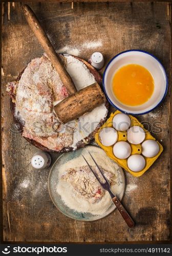 Schnitzel making, preparation composing with ingredients: meat, flour, eggs, crumbs on wooden background, top view
