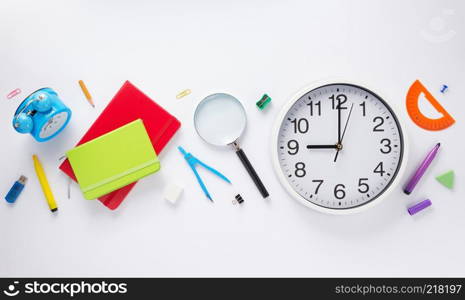 school accessories and wall clock at white background, top view