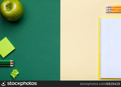 School accessories on green and yellow background. Minimal style. Flat lay. Copy space. Top view