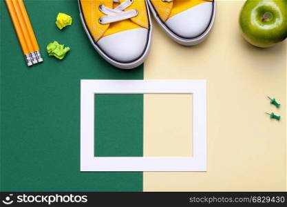 School accessories on green and yellow background. Minimal style. Flat lay. Copy space. Top view