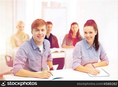 school and education concept - group of smiling students with notebooks at school. smiling students with notebooks at school