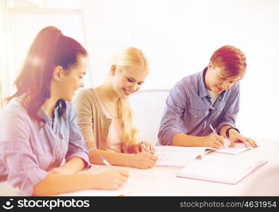 school and education concept - group of smiling students with notebooks at school. smiling students with notebooks at school