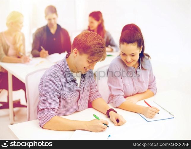 school and education concept - group of smiling students with notebooks at school. smiling students with notebooks at school
