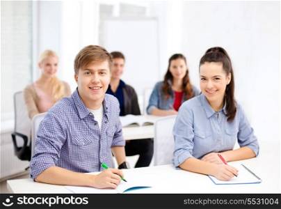 school and education concept - group of smiling students with notebooks at school