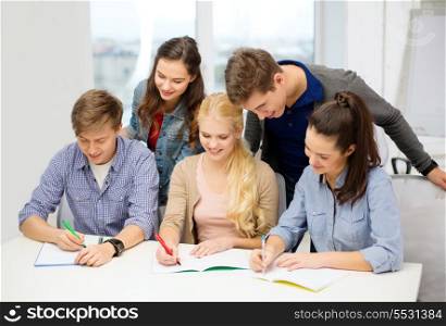 school and education concept - group of smiling students with notebooks at school
