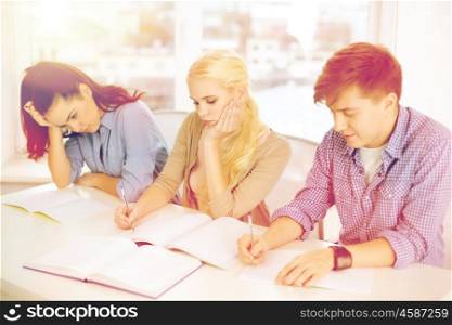school and education concept - group of tired students with notebooks at school. tired students with notebooks at school