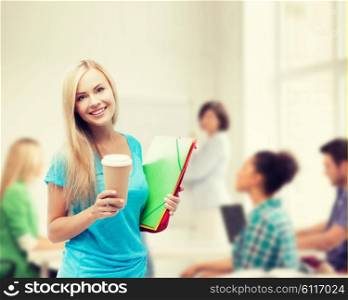 school and education concept - smiling student with folders and cup of coffee. smiling student with folders