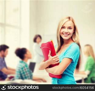 school and education concept - smiling student with folders. smiling student with folders