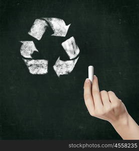 School blackboard and hand with chalk drawing recycle symbol