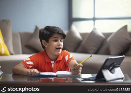 SCHOOL BOY ANSWERING HIS TEACHER IN AN ONLINE SESSION 
