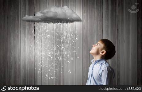 School boy. Cute boy of school age looking at pouring with characters cloud