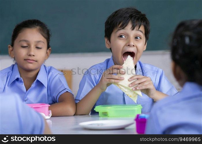 school boy eating sandwich in lunch 