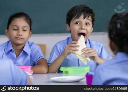 school boy eating sandwich in lunch 