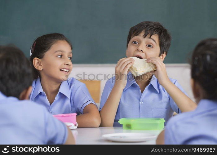 school boy eating sandwich in lunch 