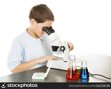 School boy in the school laboratory, looking through a microscope. White background.