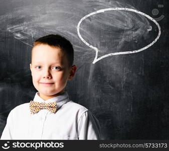 school boy is standing with blackboard behind him