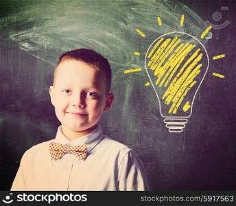 school boy. school boy is standing with blackboard behind him