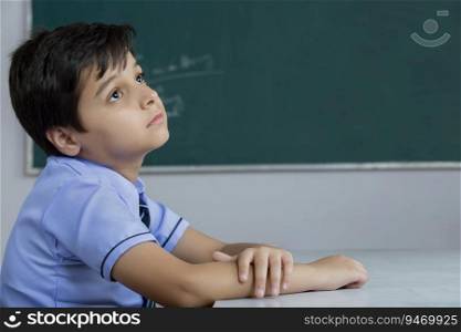school boy sitting in his class and thinking about something