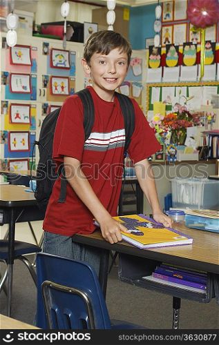 School boy standing in classroom