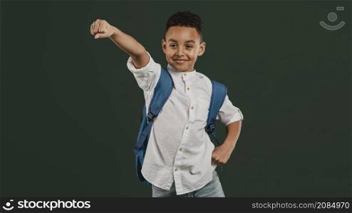 school boy standing superhero position