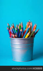 school - bucket with colorful pencils on a blue background