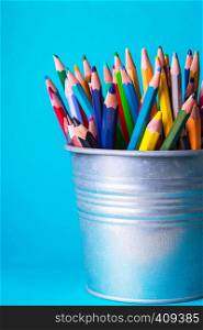 school - bucket with colorful pencils on a blue background