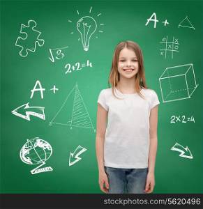 school, childhood and education concept - smiling little girl in white blank t-shirt over green board background